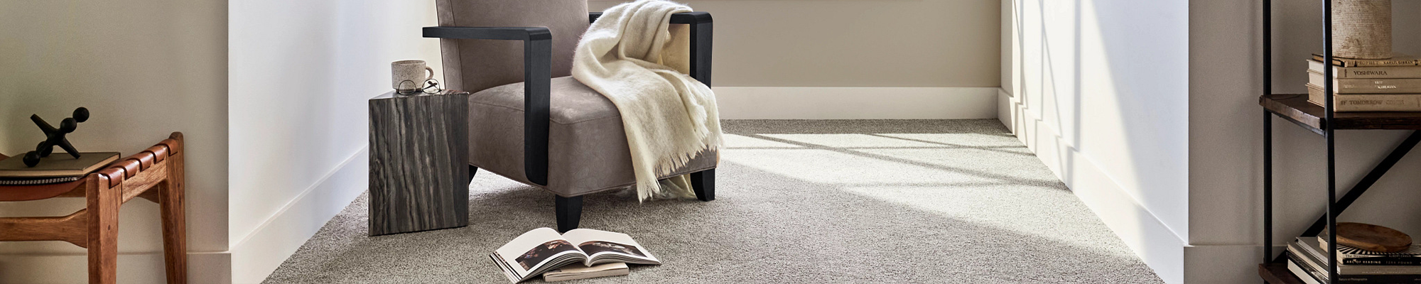 cushioned chair on carpet with book and blanket - Peoples Signature Flooring in TX