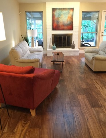 living room with hardwood floor Peoples Signature Flooring Austin Texas, 7.5 Inch Wide Hand Sculpted Acacia Natural 1x8 Baseboards